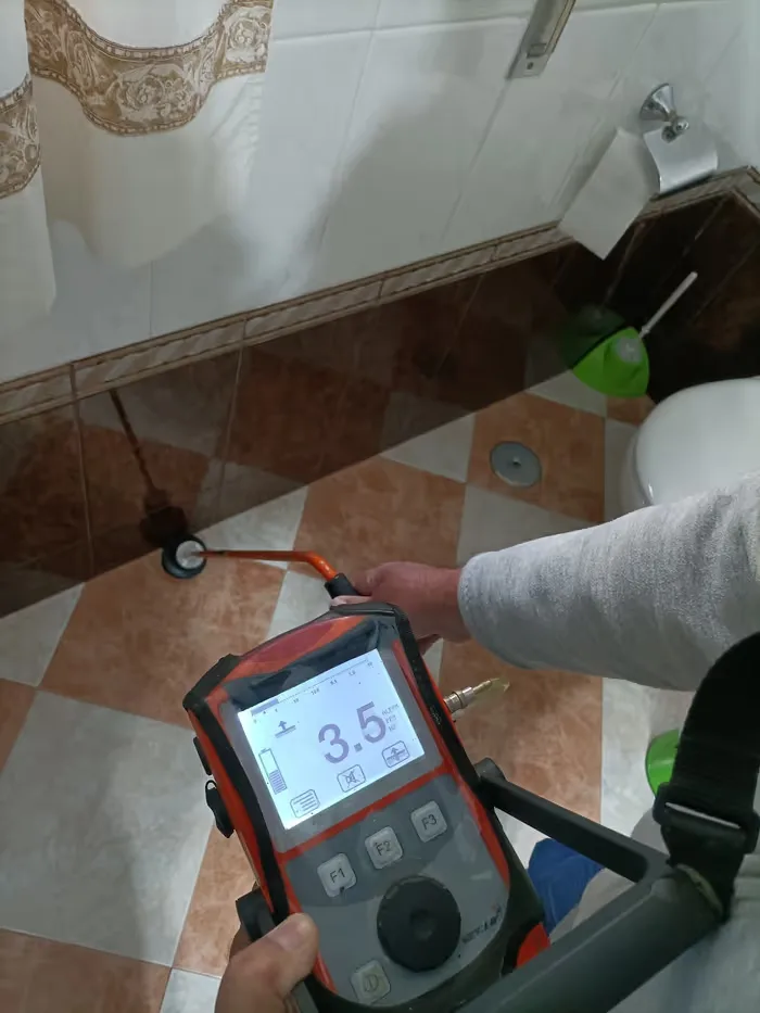 Detector de fugas midiendo junto al suelo de un baño