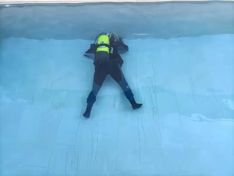Buzo revisando el fondo de una piscina